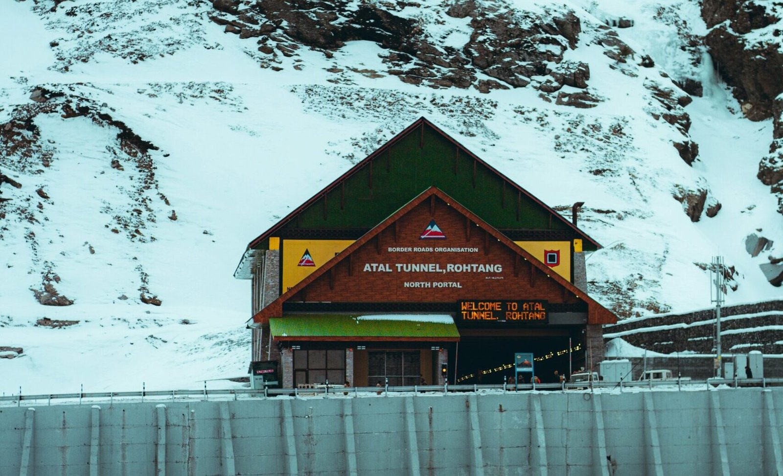 a snow covered mountain with a building on top of it